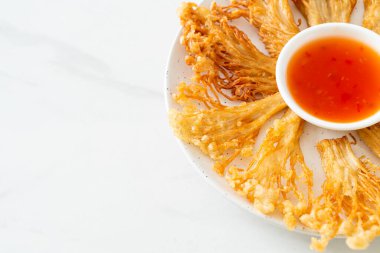 Kızarmış enoki mantarı ya da baharatlı soslu altın iğneli mantar - vejetaryen yemek tarzı.