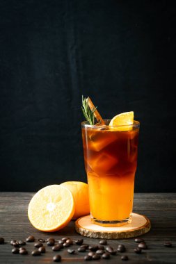 Bir bardak buzlu americano sade kahve ve biberiye ve tarçınla süslenmiş portakal ve limon suyu.