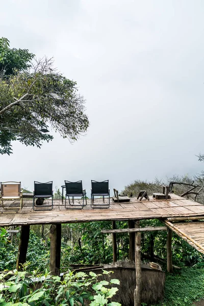 山の丘と霧の背景を持つバルコニーの空の椅子 — ストック写真