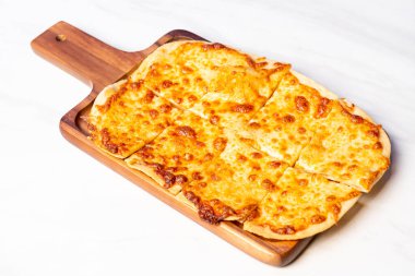 Tahtada dört peynirli tart alevli pizza.