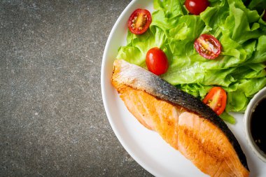 Kızarmış somon bifteği ve sebze salatası. Sağlıklı yemek tarzı.