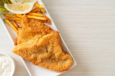 balık ve patates kızartması - kızarmış balık fileto patates cipsi ve limonlu beyaz tabak
