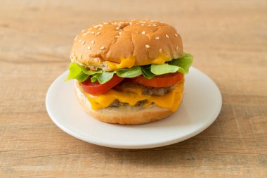 Beyaz tabakta peynirli domuz burger.