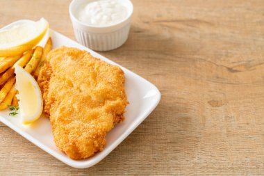 balık ve patates kızartması - kızarmış balık fileto patates cipsi ve limonlu beyaz tabak