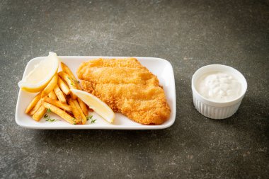 balık ve patates kızartması - kızarmış balık fileto patates cipsi ve limonlu beyaz tabak