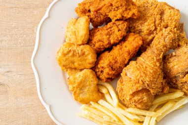 Patates kızartmalı kızarmış tavuk ve tabakta nugget - sağlıksız yemek.