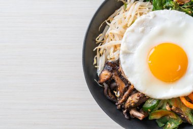 Bibimbap, Kore baharatlı salata pilav ve sahanda yumurta. Geleneksel Kore yemeği tarzı.