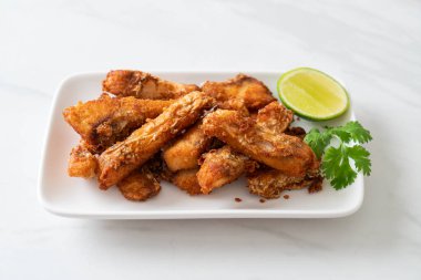 Fried Snapper Belly on white plate - Asian food style
