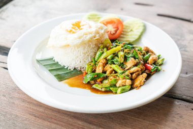 rice and stir fried chicken with basil and fried egg on top - Thai street food style