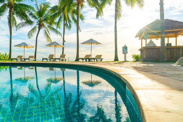 宾馆室外游泳池周围有漂亮的豪华雨伞和椅子 日落或日出时带椰子树的度假胜地 假日和度假理念 — 图库照片