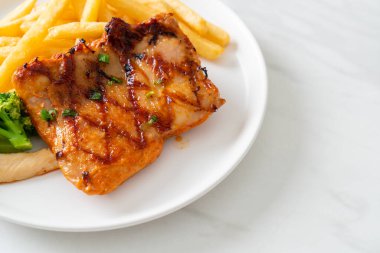 grilled chicken steak with potato chips or french fries on white plate