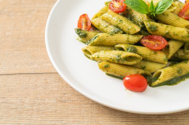 Pesto soslu ve domatesli makarna. Vejetaryen ve vejetaryen yemek tarzı.