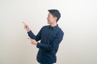 Beyaz arka planda eli işaret eden ya da sunan genç Asyalı adam portresi