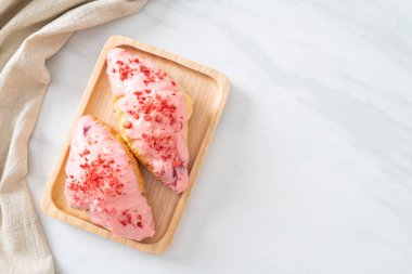 Tahta tabakta çilekli çikolata soslu kruvasan.