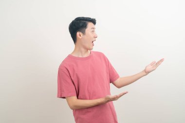 Beyaz arka planda eli işaret eden ya da sunan genç Asyalı adam portresi