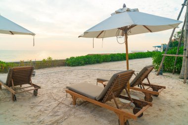 Plaj sandalyesi ve okyanus geçmişi olan şemsiye - tatil ve tatil kavramı