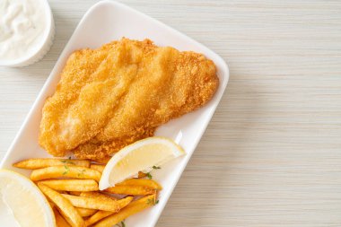 balık ve patates kızartması - kızarmış balık fileto patates cipsi ve limonlu beyaz tabak
