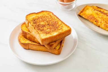 Kahvaltı için beyaz tabakta yumurtalı ekmek.