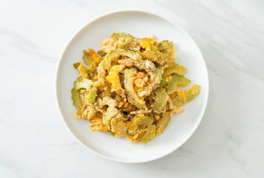 Kızarmış acı kabağı tabakta yumurta ile karıştır