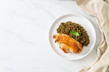 Kızarmış pesto pilavı ve beyaz tabakta kızarmış tavuk.