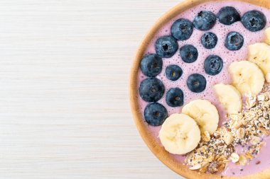 Yoğurt ya da yoğurtlu smoothie kasesi, böğürtlen, muz ve granola.