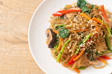 Japchae ya da karışık Kore vermicelli erişte sebzeli ve üzerine beyaz susamlı domuz eti - Kore geleneksel yemek tarzı