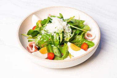 Kaynamış yumurtalı taze sebze. Tabakta balzamik salata.