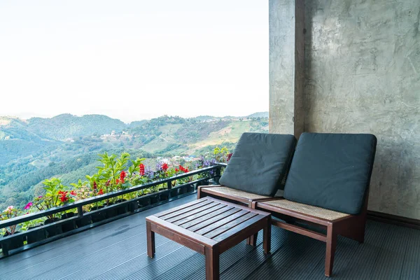 empty chair on balcony with mountain hill background