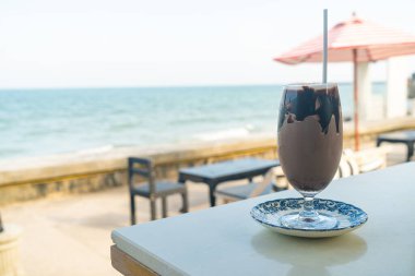 Okyanus arkaplanlı buzlu çikolatalı milkshake.