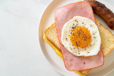 Ev yapımı kızarmış peynir üzerine jambon ve kahvaltıda domuz sosisli sahanda yumurta.