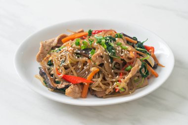Japchae ya da karışık Kore vermicelli erişte sebzeli ve üzerine beyaz susamlı domuz eti - Kore geleneksel yemek tarzı