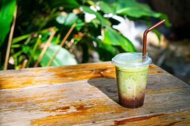 Buzlu yeşil çay, ahşap masadaki çikolatalı.