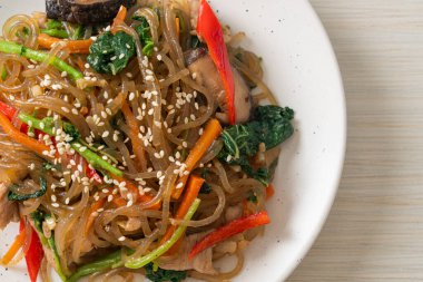 Japchae ya da karışık Kore vermicelli erişte sebzeli ve üzerine beyaz susamlı domuz eti - Kore geleneksel yemek tarzı