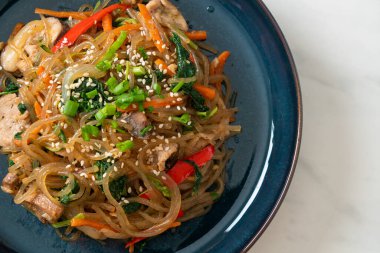 Japchae ya da karışık Kore vermicelli erişte sebzeli ve üzerine beyaz susamlı domuz eti - Kore geleneksel yemek tarzı