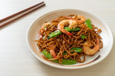 Kızarmış yakisoba eriştesi, yeşil bezelye ve karides, Asya usulü.