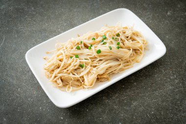 Karıştırılmış altın iğneli mantar, beyaz tabakta tereyağı.