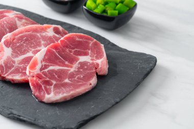 Taze domuz boyunlu ya da yakalı domuz eti ve terbiye edilecek malzemeler.