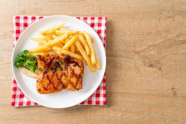 grilled chicken steak with potato chips or french fries on white plate