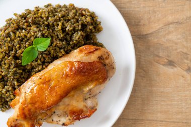 Kızarmış pesto pilavı ve beyaz tabakta kızarmış tavuk.