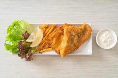 balık ve patates kızartması - kızarmış balık fileto patates cipsi ve limonlu beyaz tabak