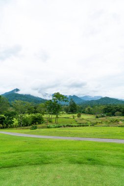 Green and Sand bunkers on Golf course with mountain hill background