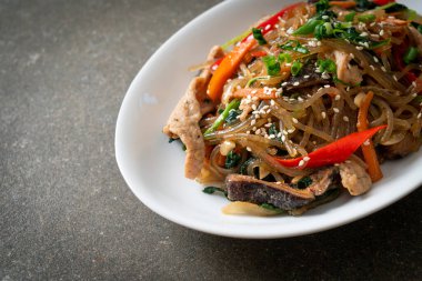 Japchae ya da karışık Kore vermicelli erişte sebzeli ve üzerine beyaz susamlı domuz eti - Kore geleneksel yemek tarzı