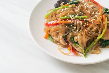 Japchae ya da karışık Kore vermicelli erişte sebzeli ve üzerine beyaz susamlı domuz eti - Kore geleneksel yemek tarzı