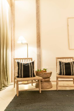 Lüks otel dinlenme odası ve yatak odasında beyaz yastıklar koltukta süslenir.