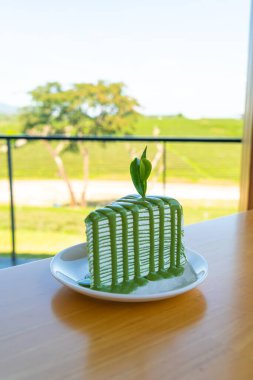 Beyaz tabakta kibrit yeşil çay krepi keki