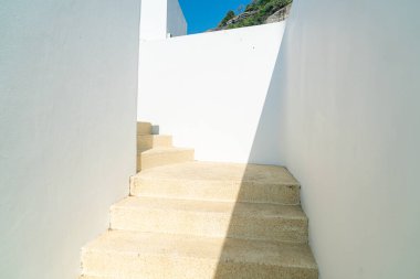 Beyaz duvar ve mavi gökyüzü ile merdiven basamağı