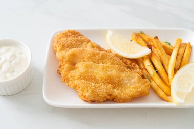 balık ve patates kızartması - kızarmış balık fileto patates cipsi ve limonlu beyaz tabak