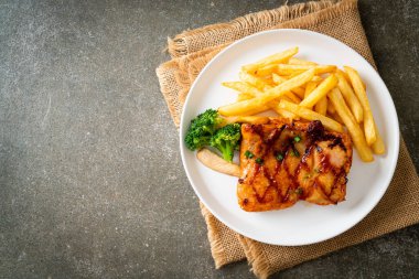grilled chicken steak with potato chips or french fries on white plate