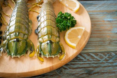 Tahtada limon olan taze peygamber devesi karidesi.