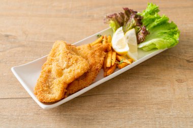 balık ve patates kızartması - kızarmış balık fileto patates cipsi ve limonlu beyaz tabak